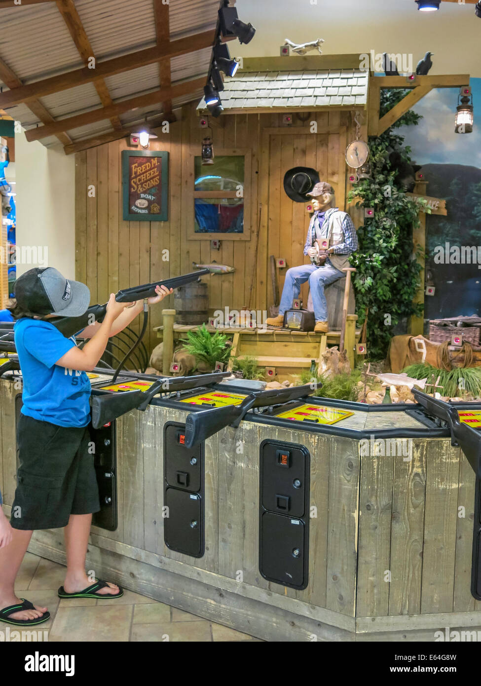 Kleiner Junge zielt auf simulierten Laser Shooting Range, Scheels Sporting Goods Store, Great Falls, Montana, USA Stockfoto