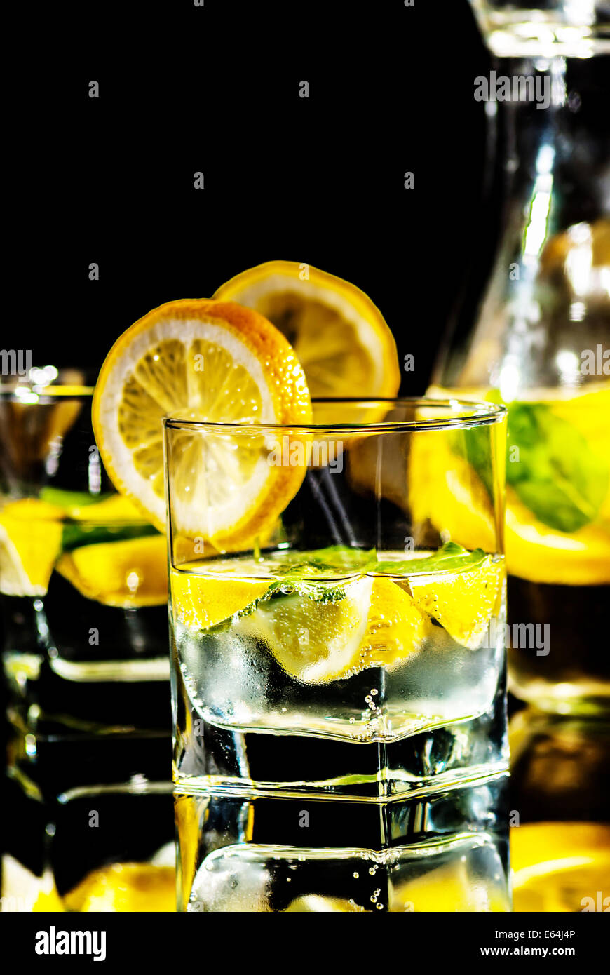 Trinken Sie Wasser mit Zitrone und Minze auf reflektieren Hintergrund Stockfoto