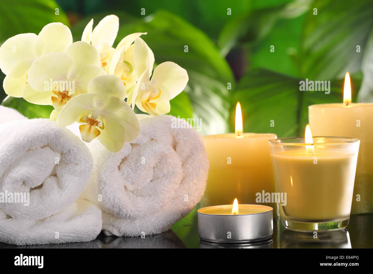 Spa-Stillleben mit Handtuch und brennenden Kerzen. Stockfoto