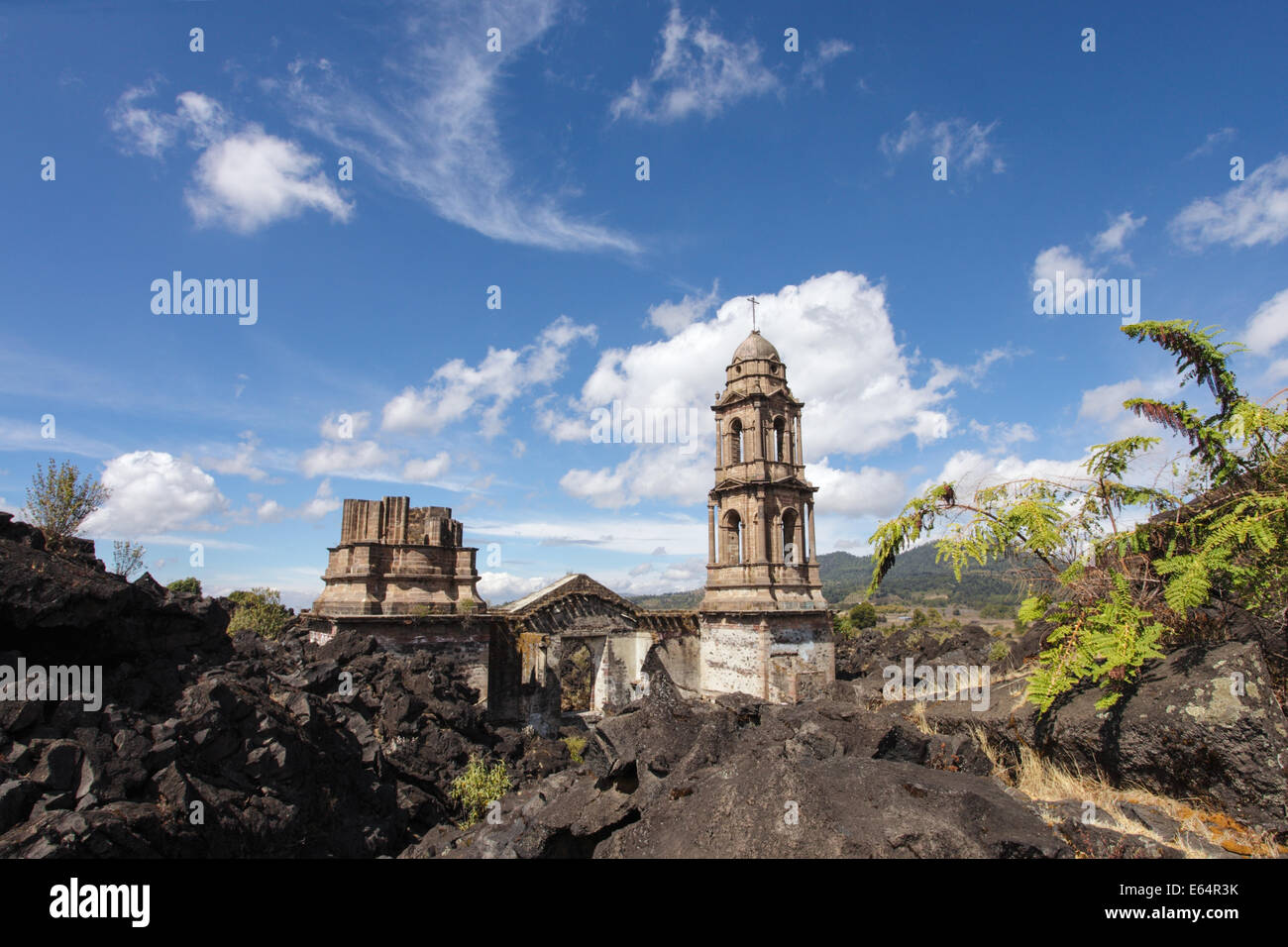 Die Türme des Tempels sind alle, die des Dorfes von Lava aus dem Vulkan Paricutín, Michoacan, Mexiko abgedeckt bleiben. Stockfoto