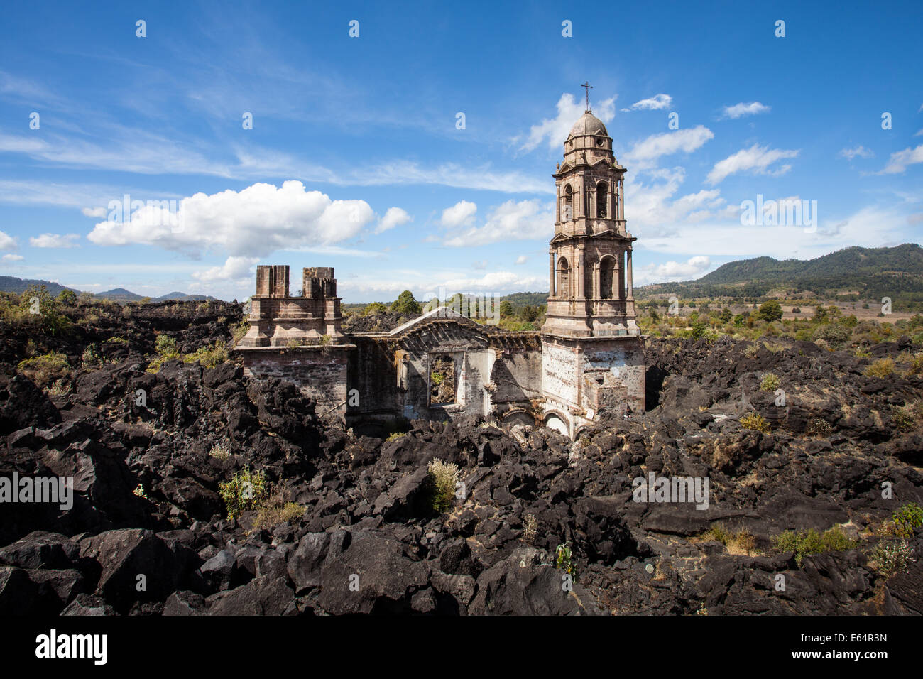 Die Türme des Tempels sind alle, die des Dorfes von Lava aus dem Vulkan Paricutín, Michoacan, Mexiko abgedeckt bleiben. Stockfoto
