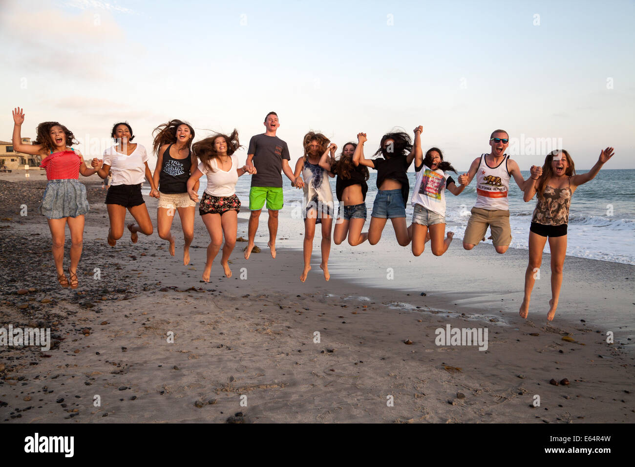 Junge Erwachsene springen am Strand, Dana Point, Kalifornien, USA Stockfoto