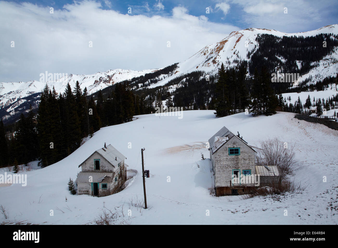 Altes Bergwerk Haus im zeitigen Frühjahr Schnee am Yankee Girl Mine, in der Nähe von Red Mountain Pass, Million Dollar Highway in der Nähe von Ouray, Colorado, U Stockfoto