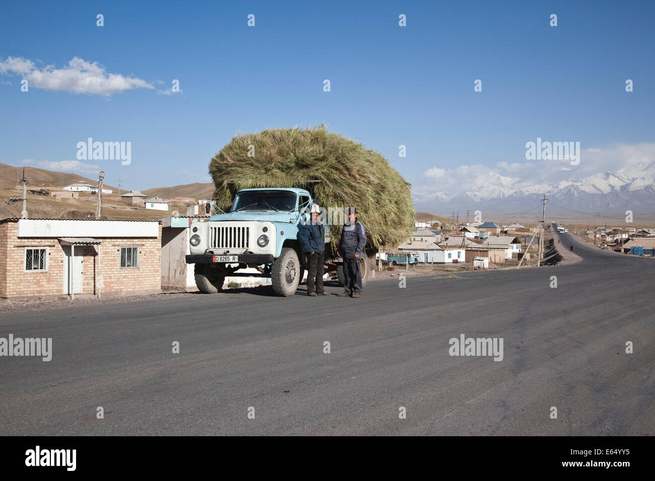 Kirgisische Männer stehen neben einem voll beladenen LKW, Sary-Tash, an der Grenze zu China, Osch, Kirgisistan Stockfoto