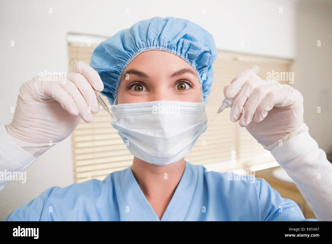 Zahnarzt in Mundschutz und Kappe halten Dentalwerkzeuge Stockfoto