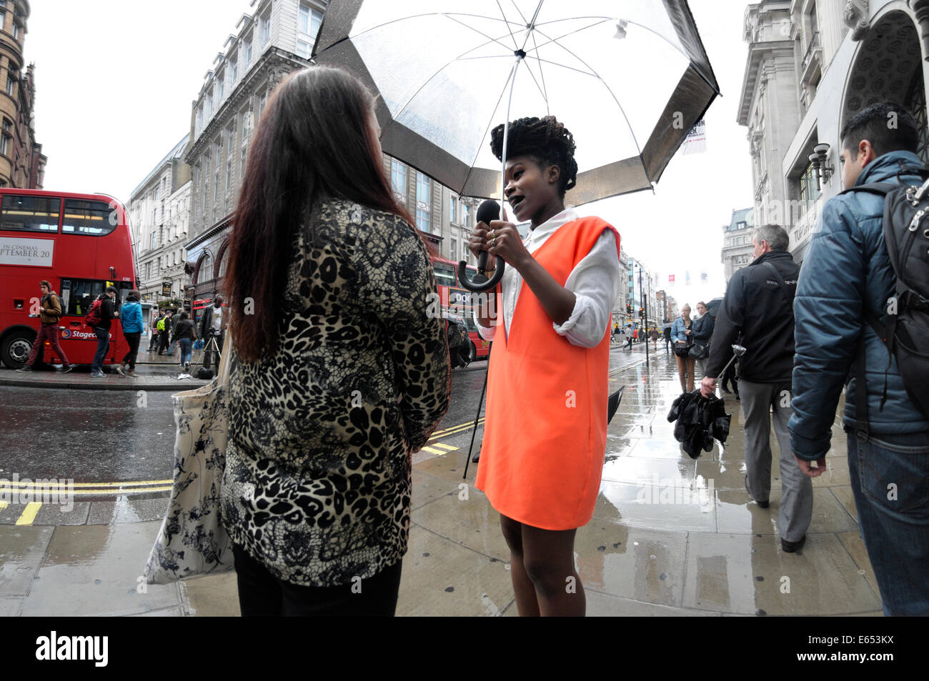 London, England, Vereinigtes Königreich. Frau, die Durchführung eines Vox-Pop-interview in der Regent Street im Regen Stockfoto