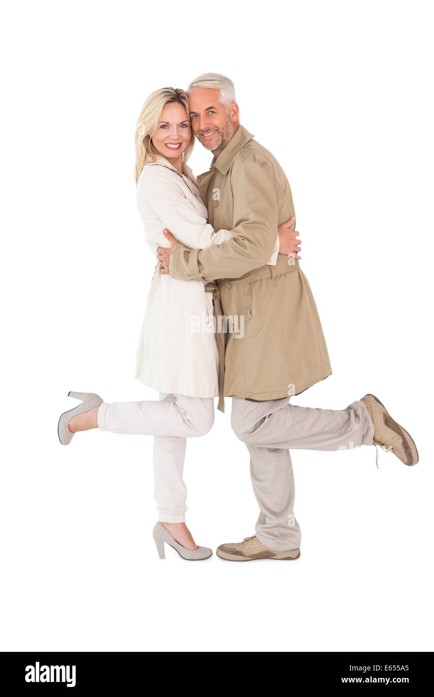 Brautpaar posiert in Trenchcoats Stockfoto