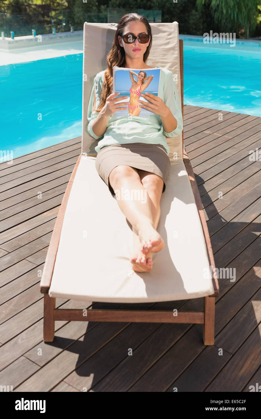 Frau Buch auf der Sonnenliege Pool Stockfoto