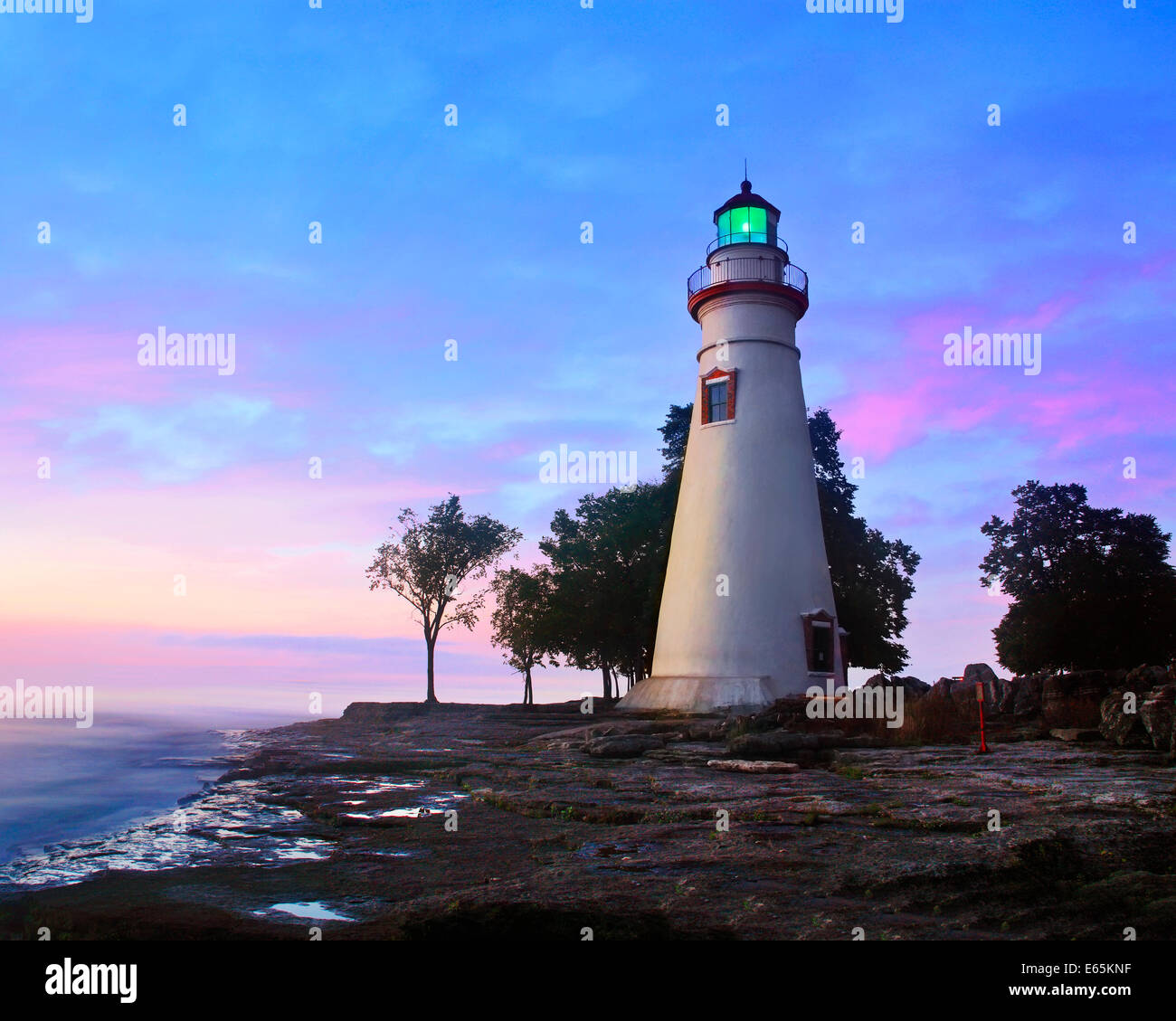 Die Marblehead Leuchtturm strahlt es Grünlicht, wie die Sonne den östlichen Himmel in Marblehead in Ohio auf See Erie, USA wärmt Stockfoto