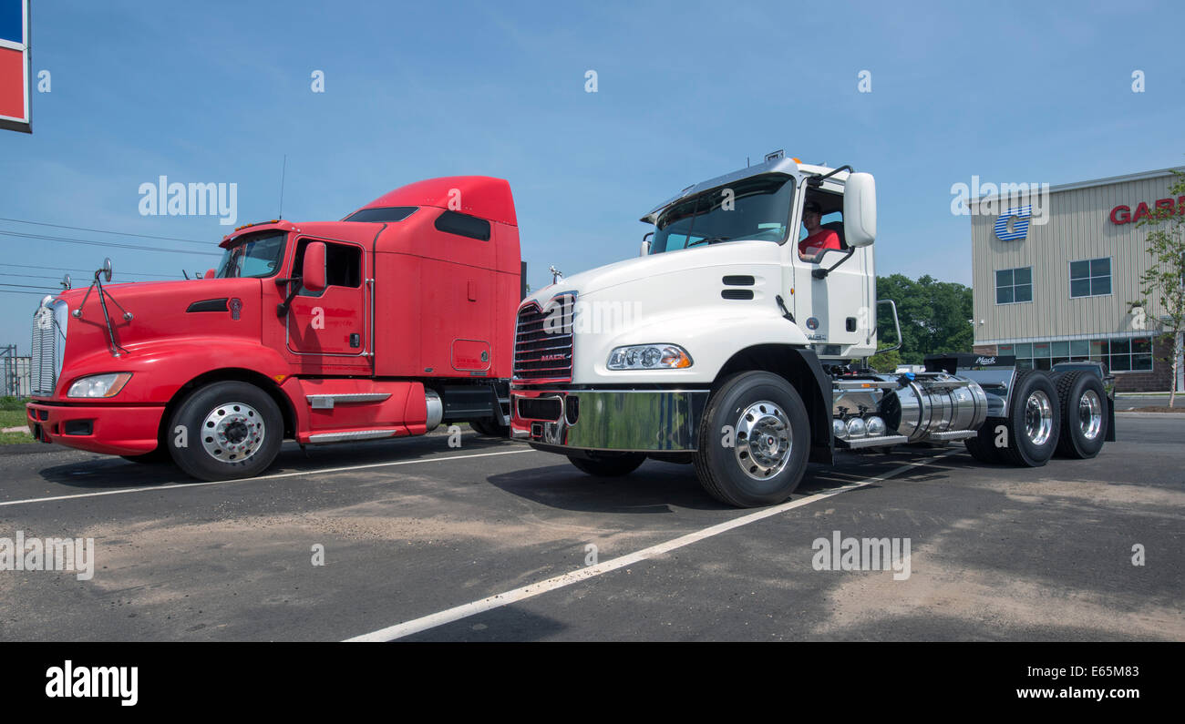 Traktor-Anhänger-LKW-Fahrerhäuser zu verkaufen.  Rot, mit Schläfer angefügt, ist ein Kenworth, weiß ein Mack. Stockfoto