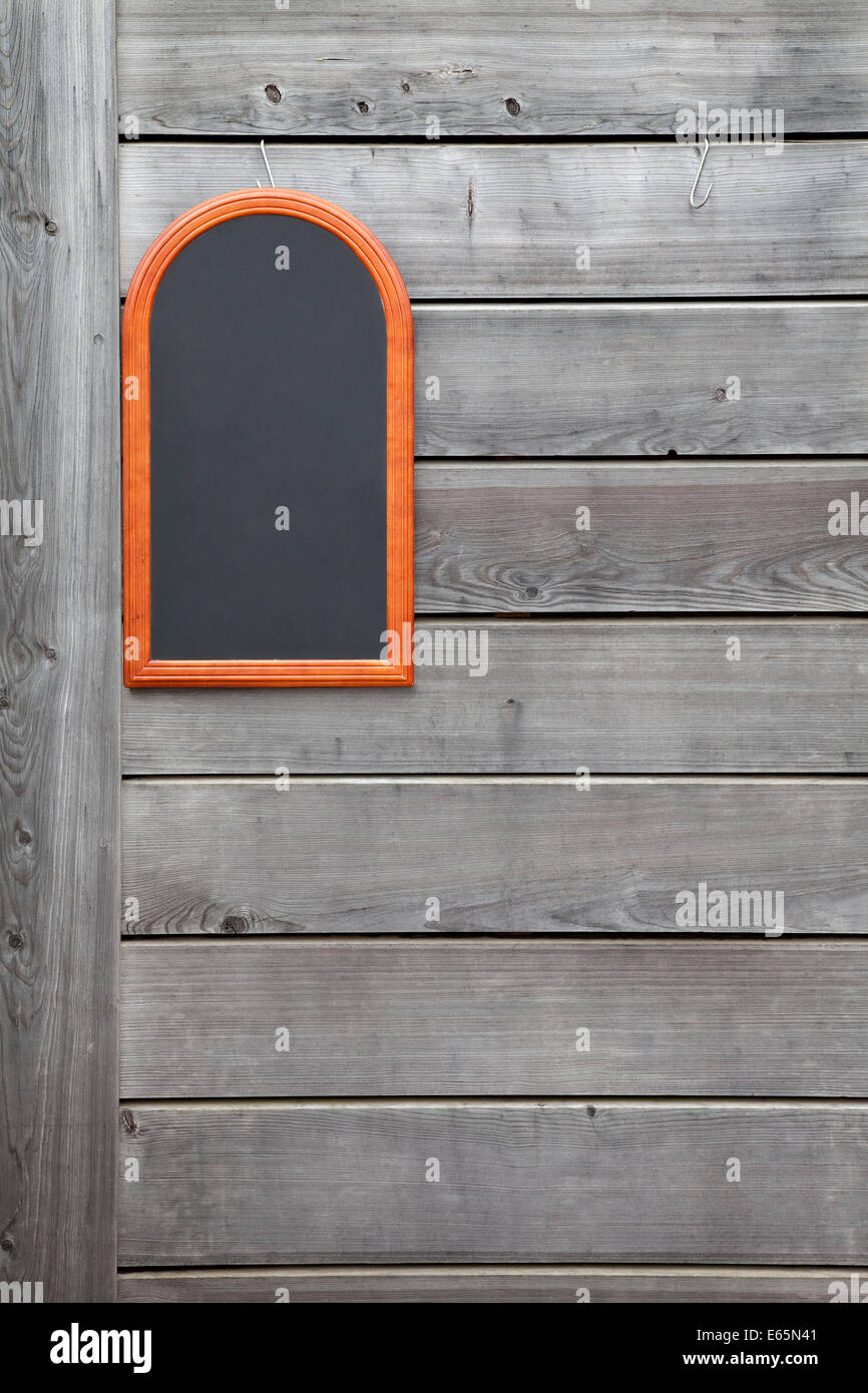 Holzwand mit einer kleinen Tafel Stockfoto