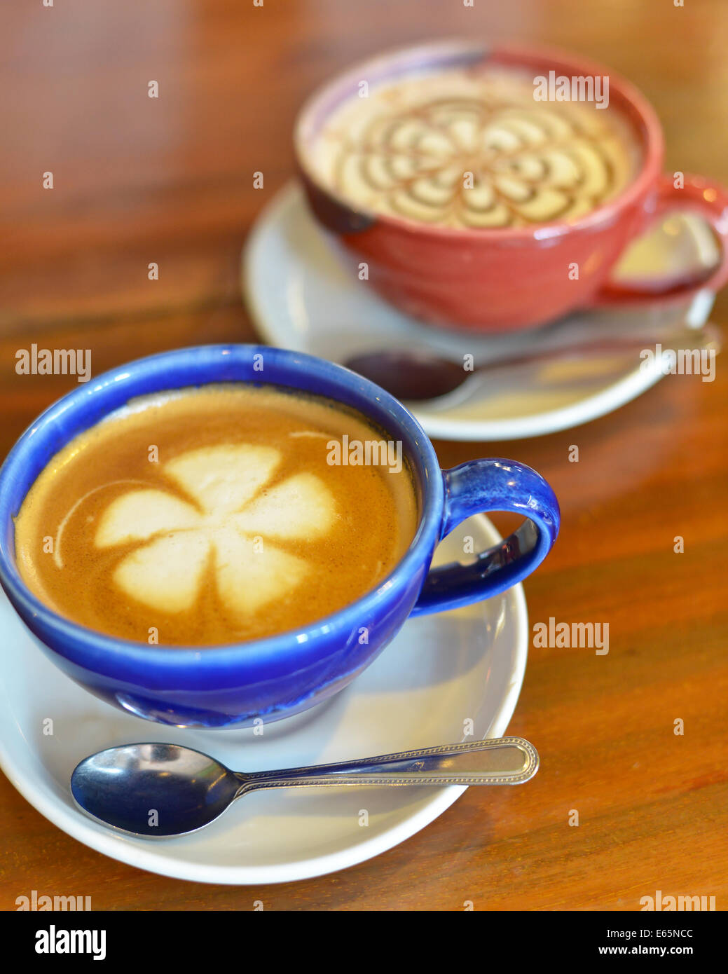 Tassen Kaffee mit Milch auf einem Holztisch. Stockfoto