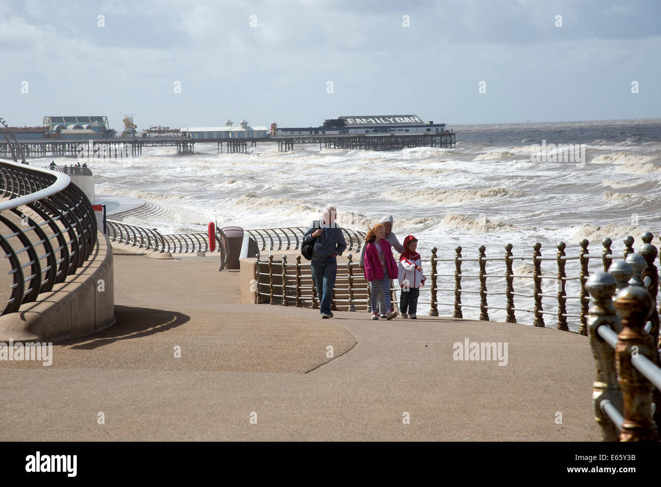 North Pier Blackpool und rauer See Urlauber auf den Abschlussball im August windigen Wetterbedingungen Stockfoto