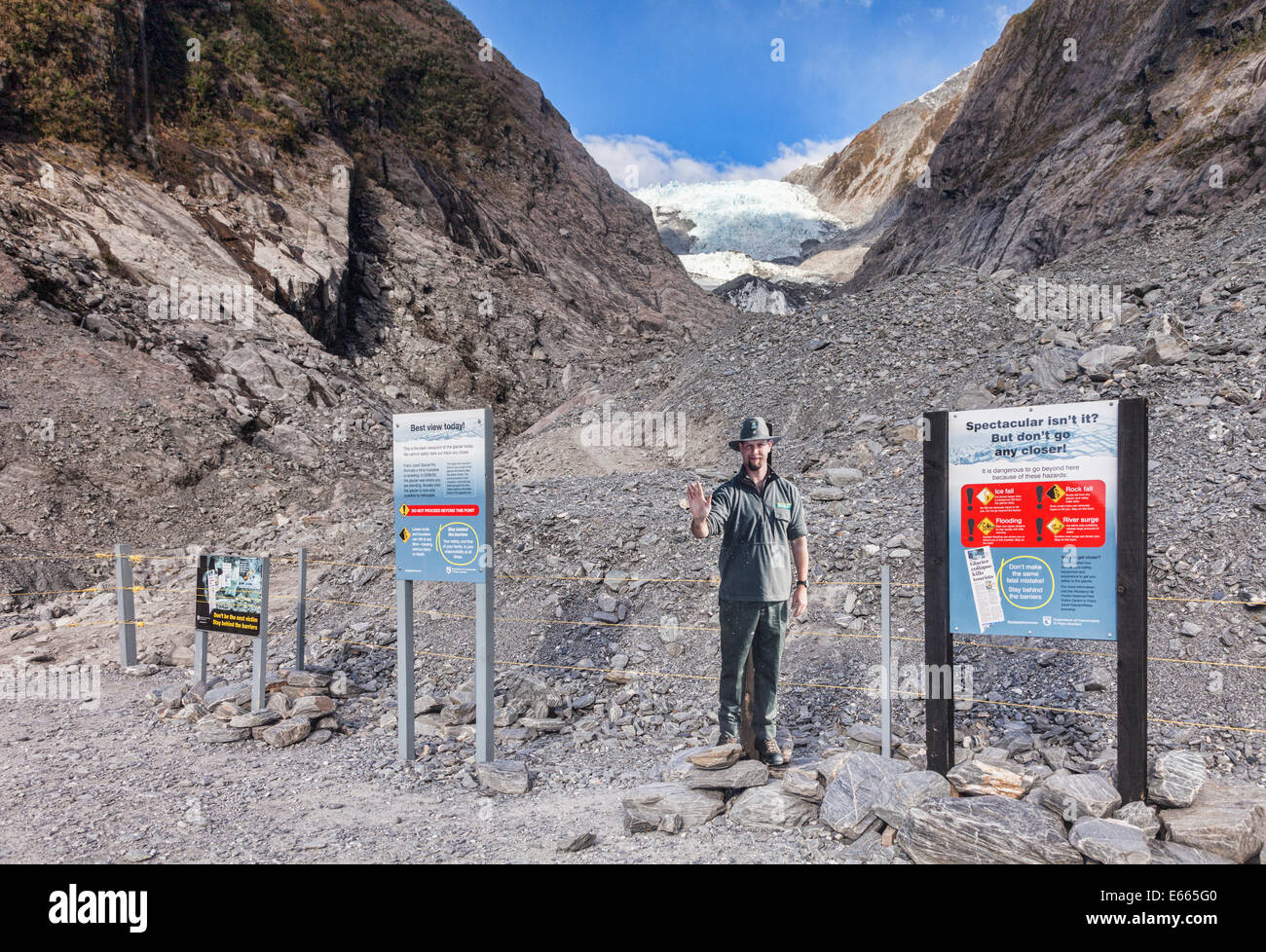 Franz Josef Glacier, mit Schild Warnung vor wie gefährlich es ist. Ranger ist ein Karton Ausschnitt. Stockfoto
