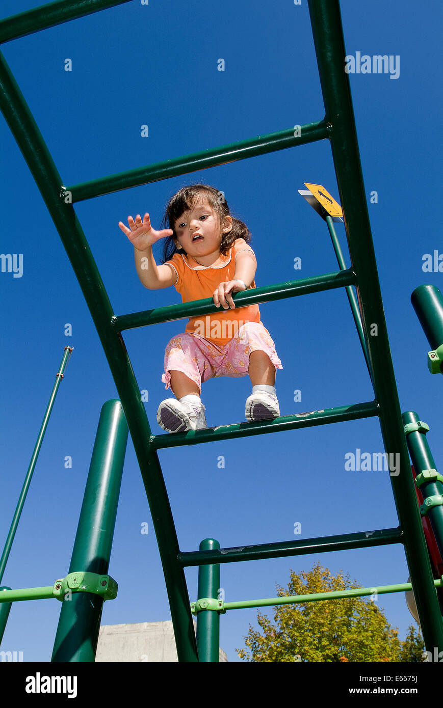 Kleinkind auf Klettergerüst klettern. Stockfoto