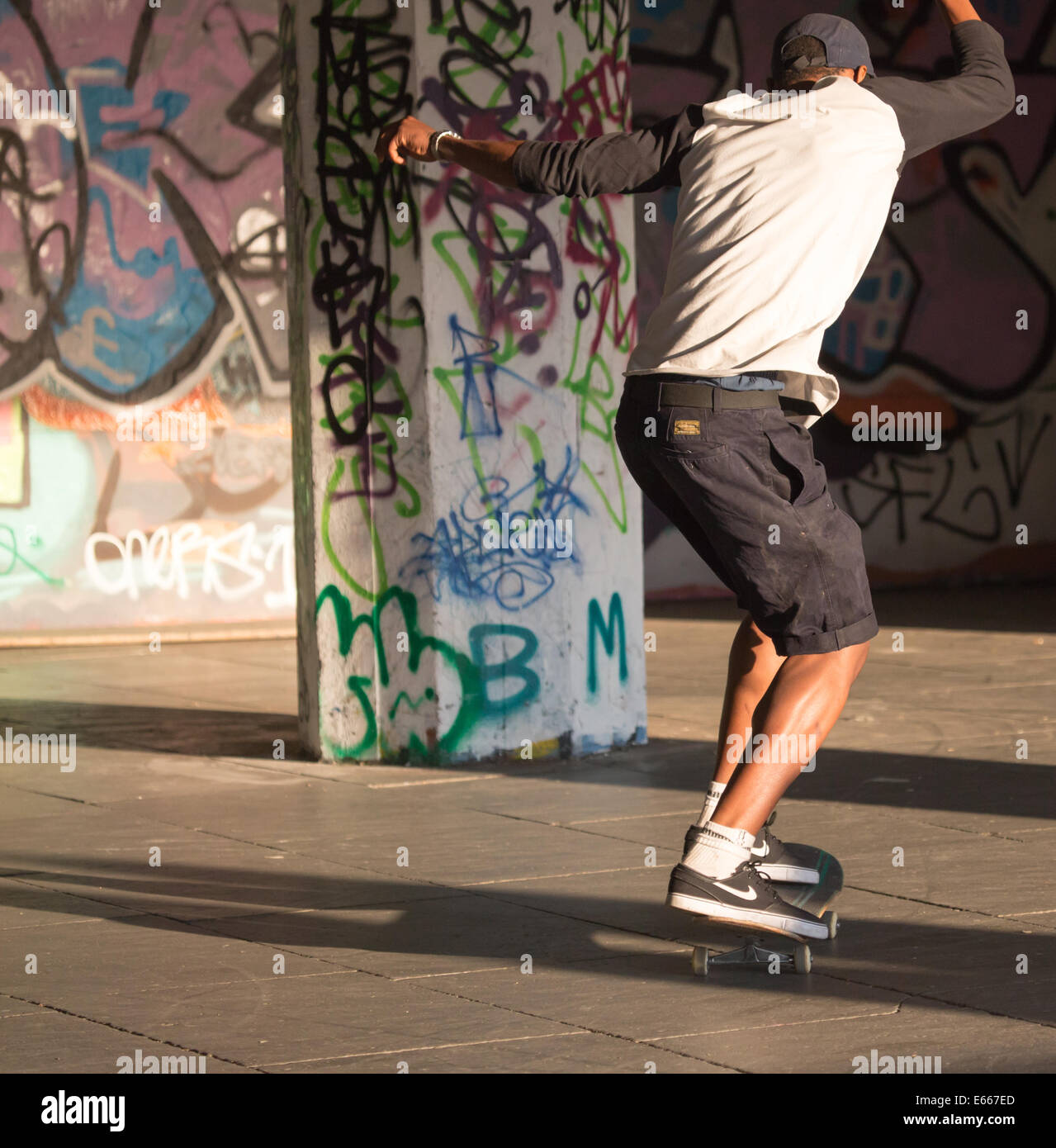 Ein junger Mann in einer Gegend mit Graffiti Skateboard Stockfoto