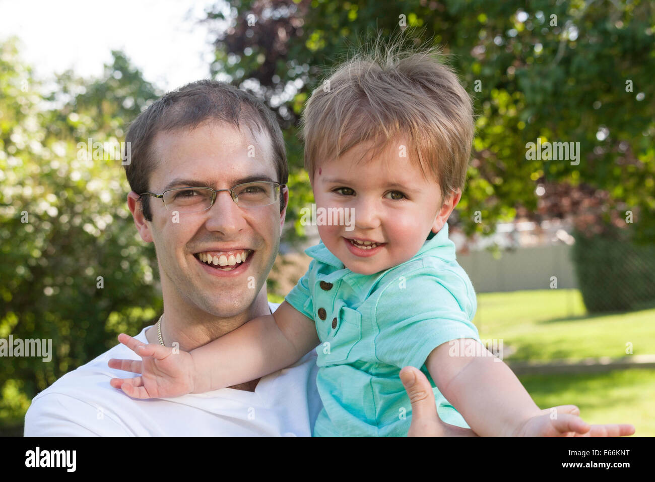 Vater und Kind Sohn Blick in die Kamera im Hinterhof, USA Stockfoto