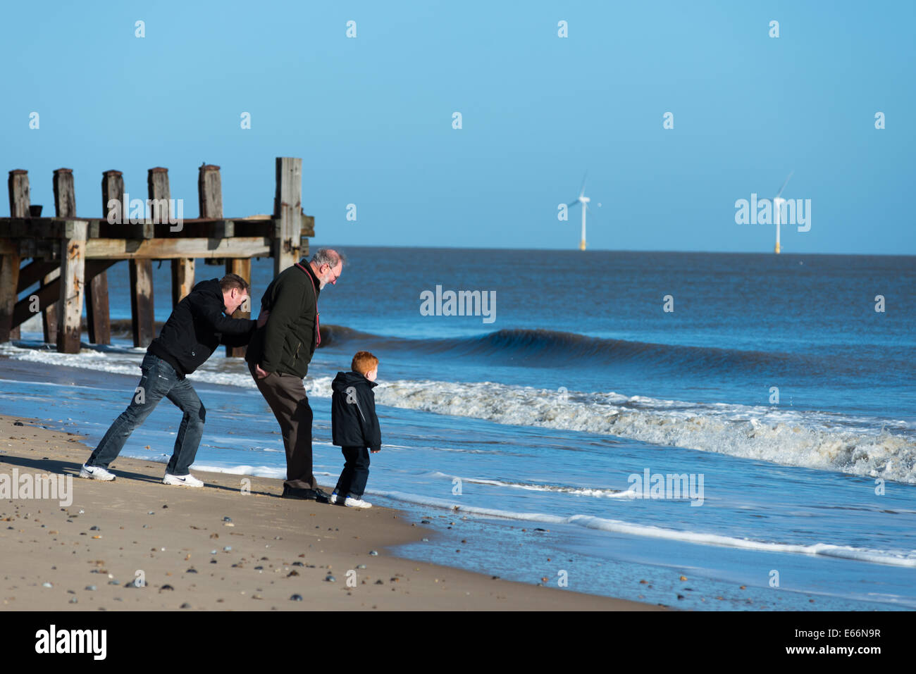 Drei Generationen von Männern am Strand von Great Yarmouth. Stockfoto