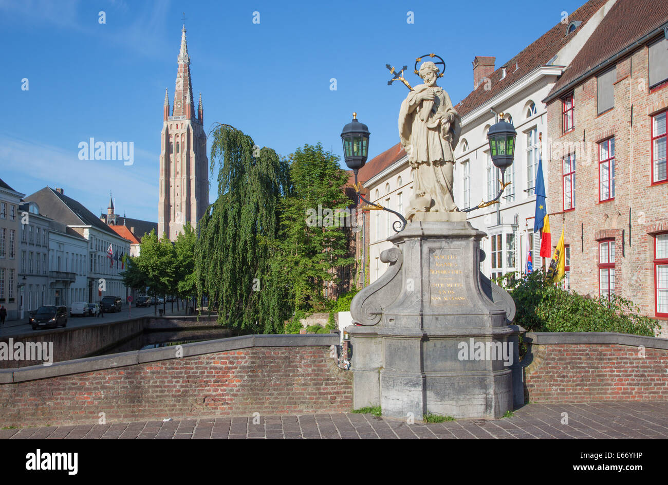 Brügge - der Turm der Liebfrauenkirche und St. Johannes Nepomuk-Statue auf der Brücke. Stockfoto