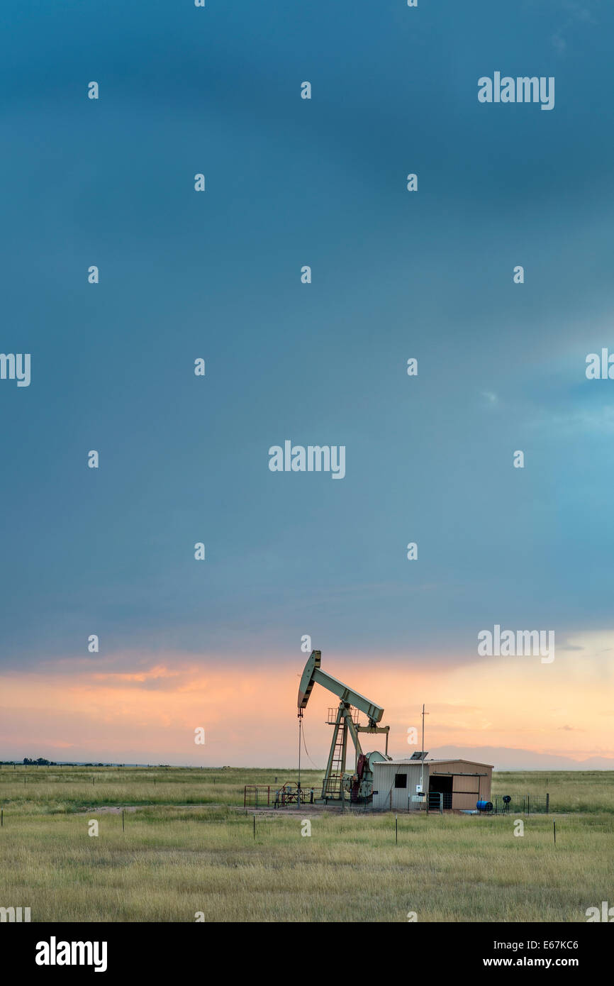Öl-Teppich (Bohrschwengels) gegen Sonnenuntergang Gewitterhimmel im Pawnee National Grassland in der Nähe von Grover, Colorado Stockfoto