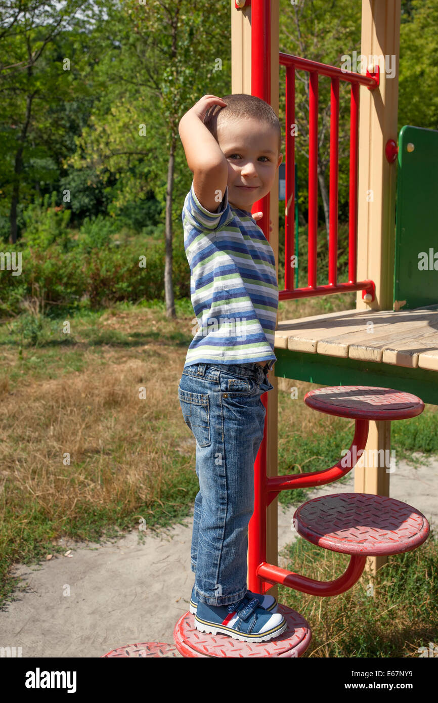 Kleiner Junge in Jeans und T-shirt auf dem Spielplatz spielen Stockfoto