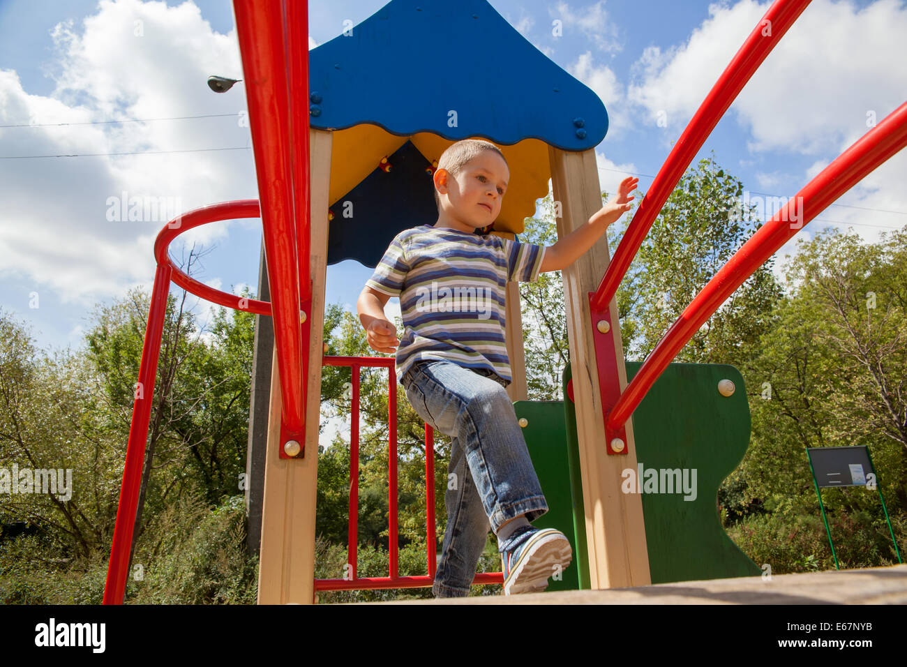 Kleiner Junge in Jeans und T-shirt auf dem Spielplatz spielen Stockfoto