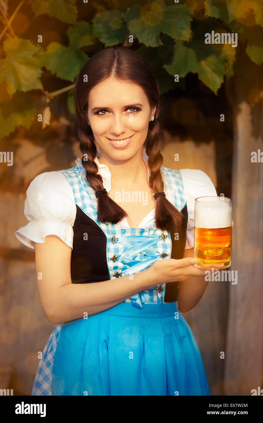 Junge bayerische Frau hält Bier Krug Stockfoto