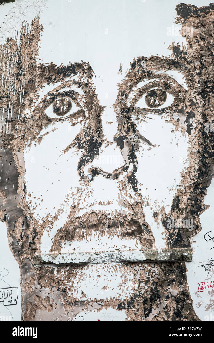 Ein Porträt von Alexandre Farto aka Vhils ausgestochen aus Beton in einer Gasse-Wand in der Nähe von Brick Lane gegründet Stockfoto