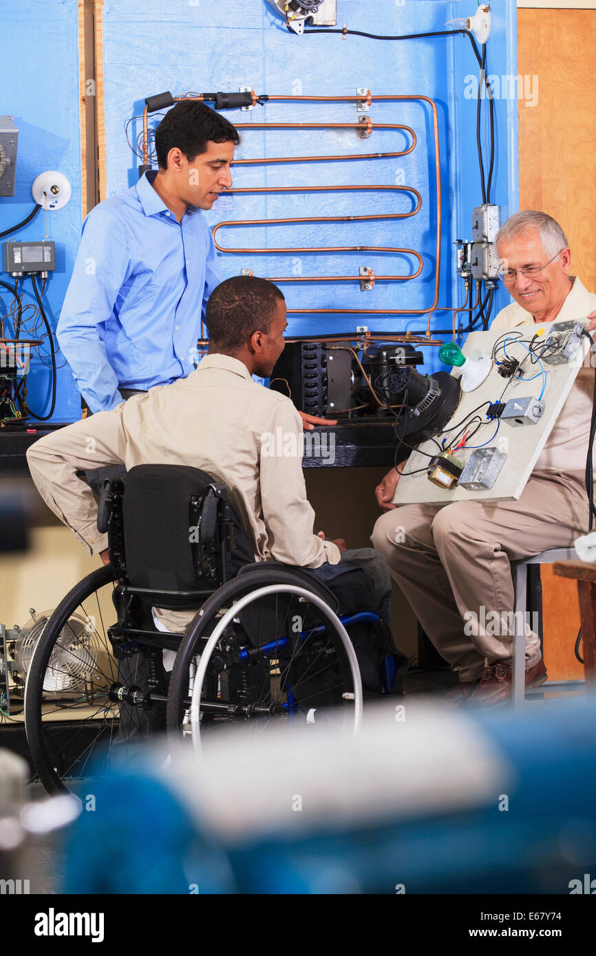 Ausbilder mit Demo-Board, HVAC Control System Betrieb ein Student im Rollstuhl zu erklären Stockfoto