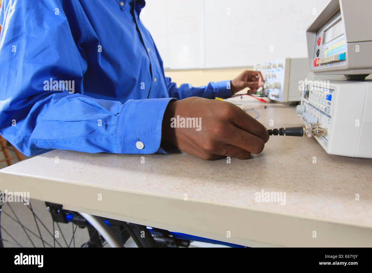 Student der Ingenieurswissenschaften in einem Elektronik-Klassenzimmer in einen Rollstuhl vom Rückenmark Meningitis Vorbereitung ein Prototyping-Steckbrett Stockfoto