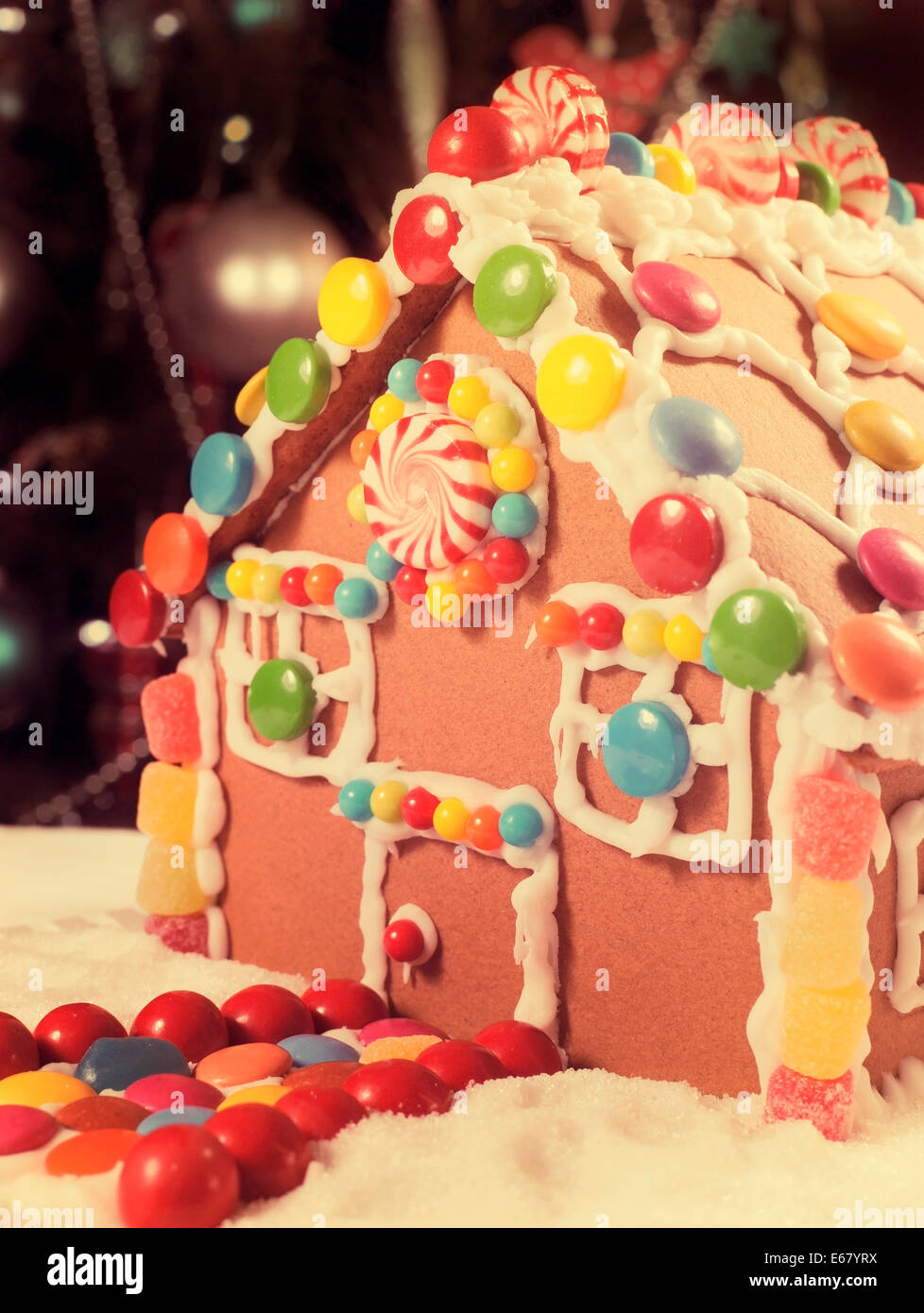 Schöne Weihnachtstisch Einstellung vor Weihnachten Baum, mit einem Lebkuchenhaus mit Zuckerguss und Süßigkeiten Süßigkeiten gemacht, Stockfoto