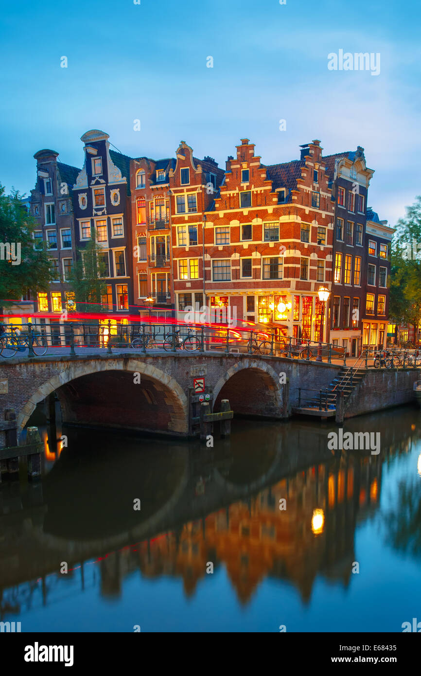 Nacht-Stadtansicht von Amsterdam Canal, Brücke und typische Häuser, Boote und Fahrräder, Holland, Niederlande. Stockfoto