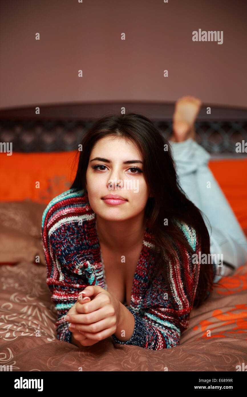 Glücklich attraktive Frau liegend auf dem Bett zu Hause Stockfoto