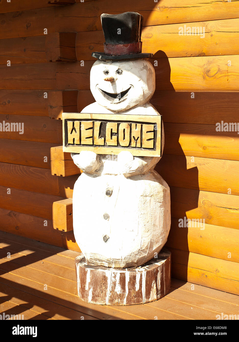 Holz Schneemann auf Veranda von einem Blockhaus Stockfoto