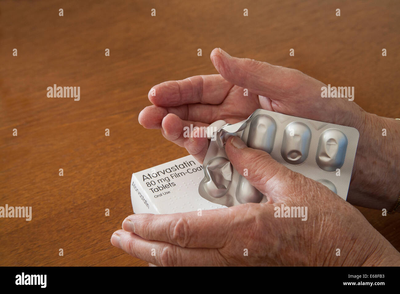 Ältere Frau mit hohem Cholesterinspiegel statin Tablet in der Hand aus Blisterpackung Pressen Stockfoto