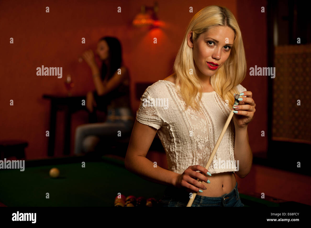 Schöne junge Blondine in einer Bar Billard spielen Stockfoto