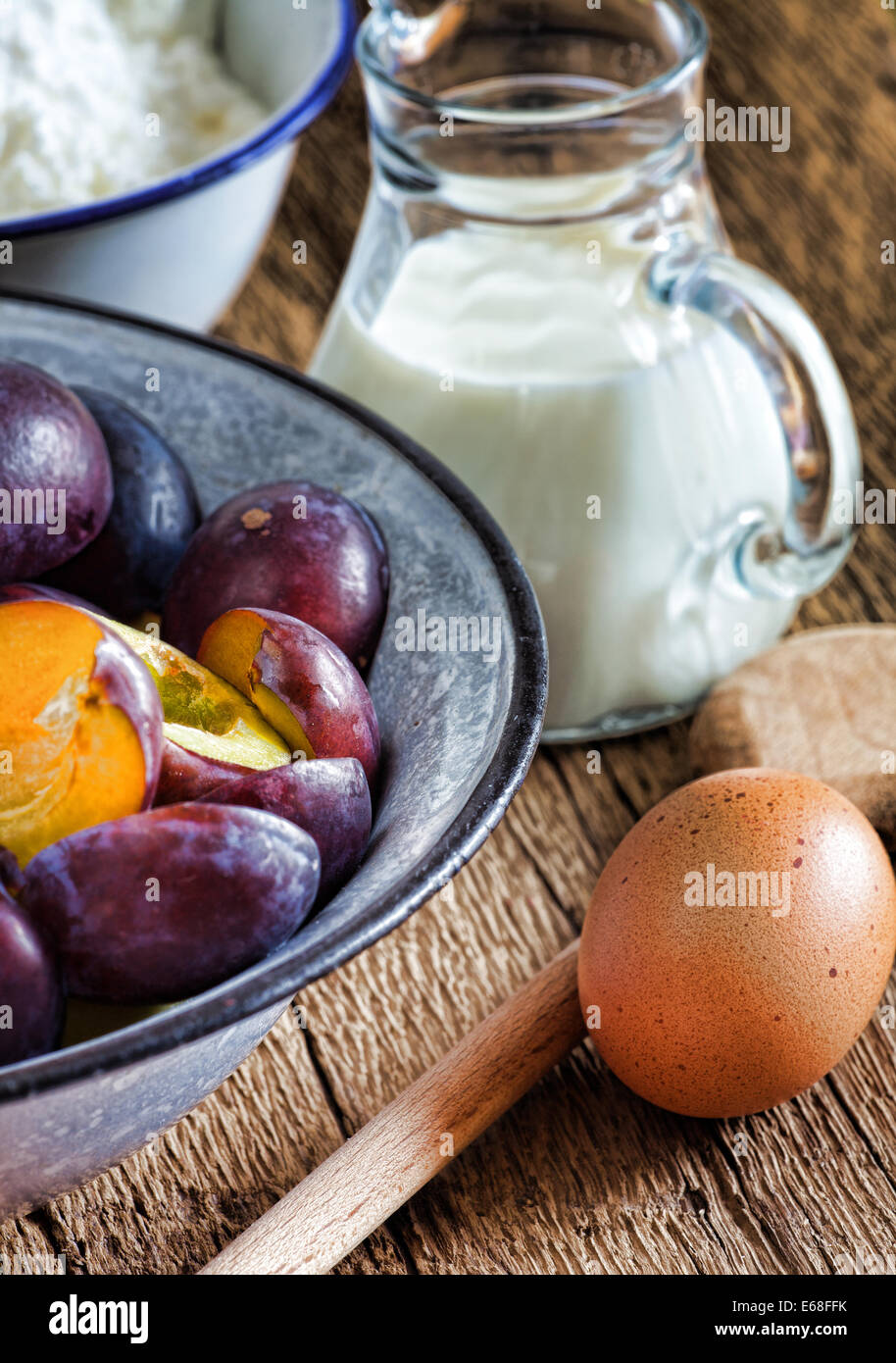 Zutaten zu einer Pflaume Kuchen auf einem rustikalen Holztisch Stockfoto