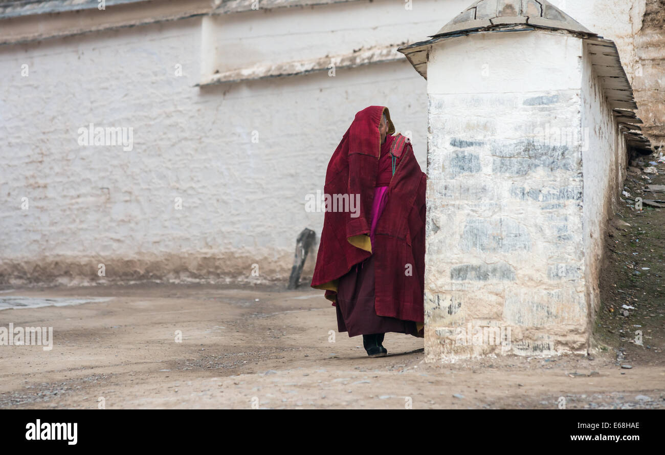 Alter Tibetische Mönch Labrang Kloster ist aus einer Menge von China Fotografen hinter der Wand versteckt. Stockfoto