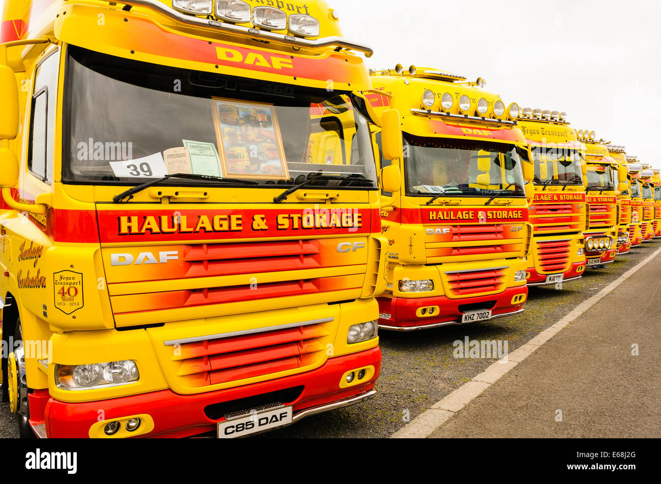 Zeile mit gelben und roten Lastwagen bis geparkt. Stockfoto