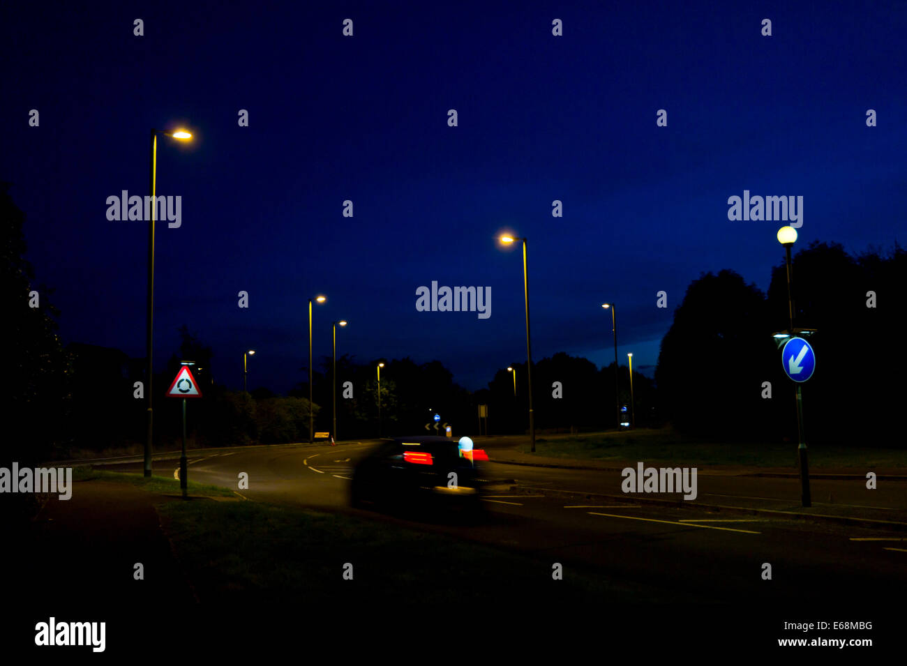 Straßenlaternen beleuchten Straße in der Nacht. Stockfoto