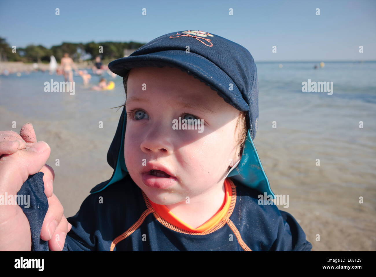 Einen einjährigen kaukasischen jungen im Urlaub einen Hut am Strand, La Trinité-Sur-Mer, Bretagne, Frankreich Stockfoto