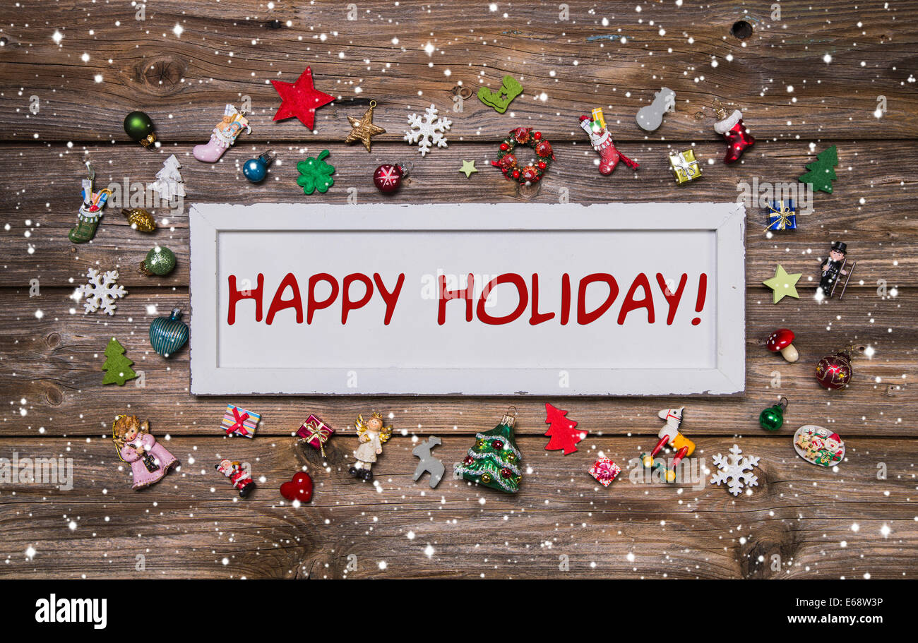 Happy Holiday - Glückwunsch Weihnachtskarte in verschiedenen Farben auf hölzernen Hintergrund. Stockfoto