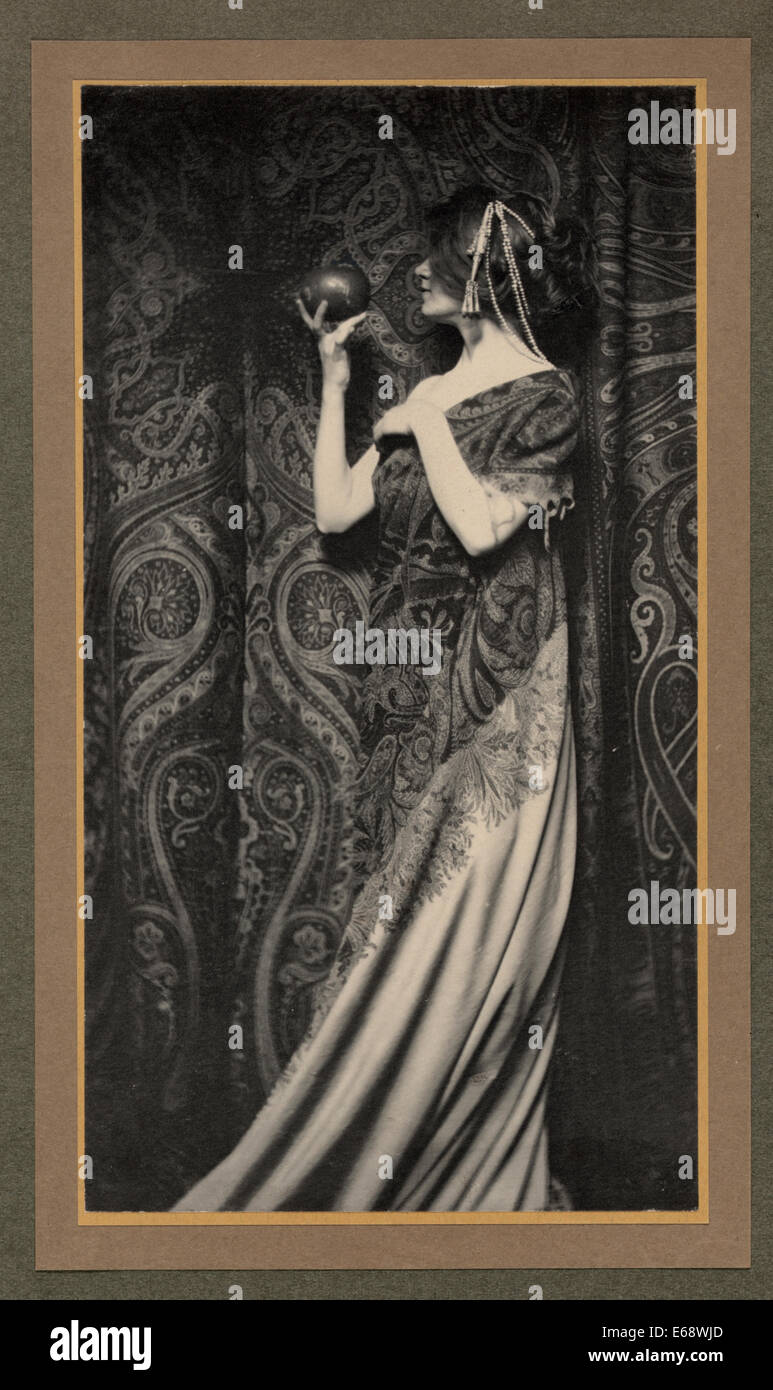 Der Geruch von Granatäpfeln - Zusammenfassung: das Foto zeigt eine Frau trägt ein langes fließende Kleid, steht man vor den Vorhang, Verkleidung links, halten einen Granatapfel, um 1900 Stockfoto