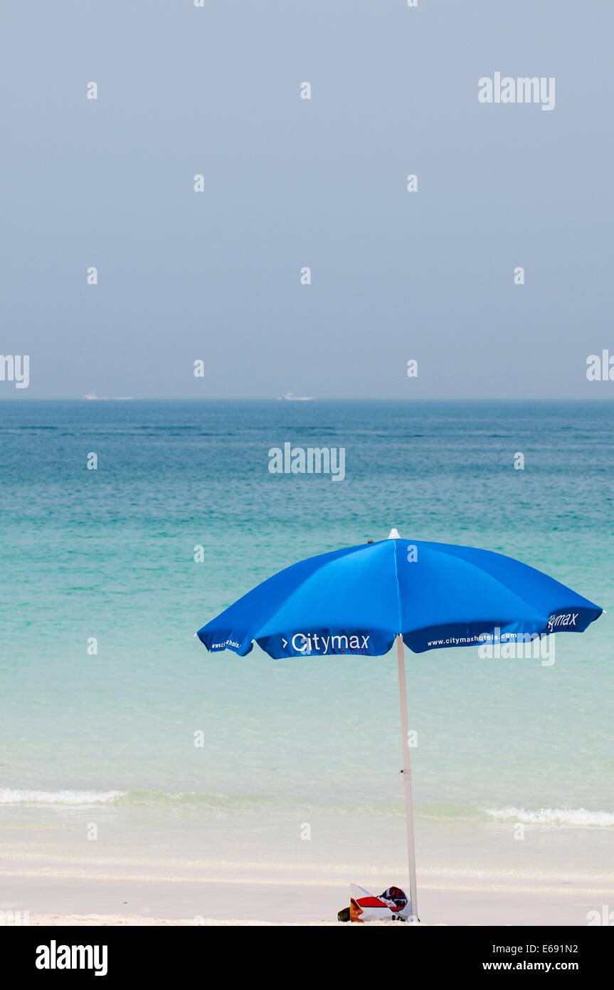 Blauen Sonnenschirm am Strand von Jumeirah, Dubai, Vereinigte Arabische Emirate (VAE). Stockfoto