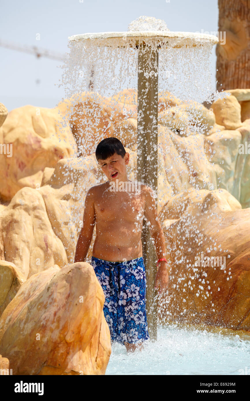 Junge im tunesischen Aquapark, Wasser-Park-Resort unter Dusche Stockfoto