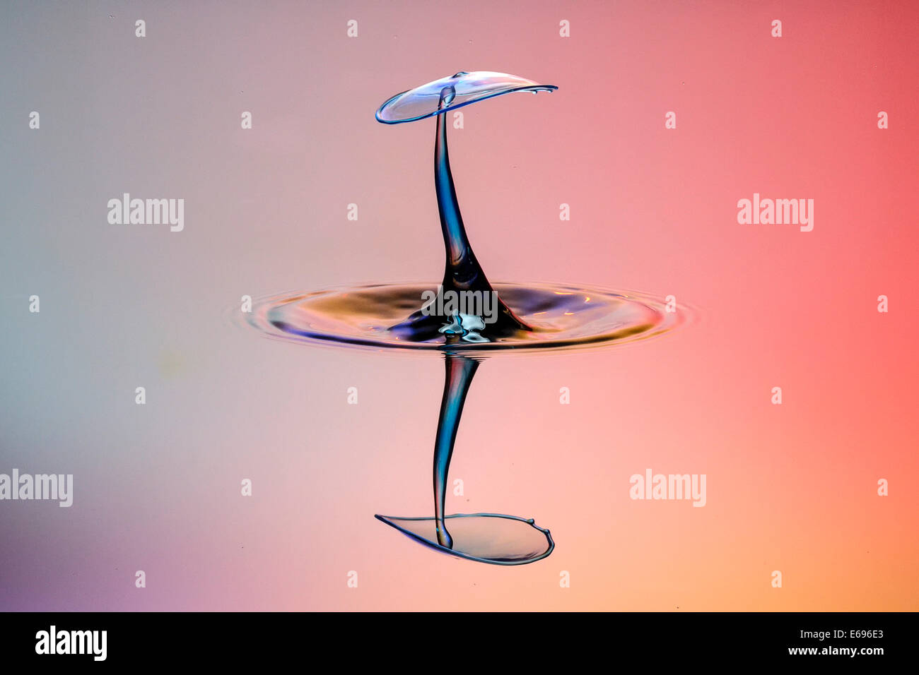 Drei Tropfen kollidieren, der erste bildet eine Spalte, die zweite erzeugt das Schild, gefolgt von der dritten, digital gesteuert mit Stockfoto