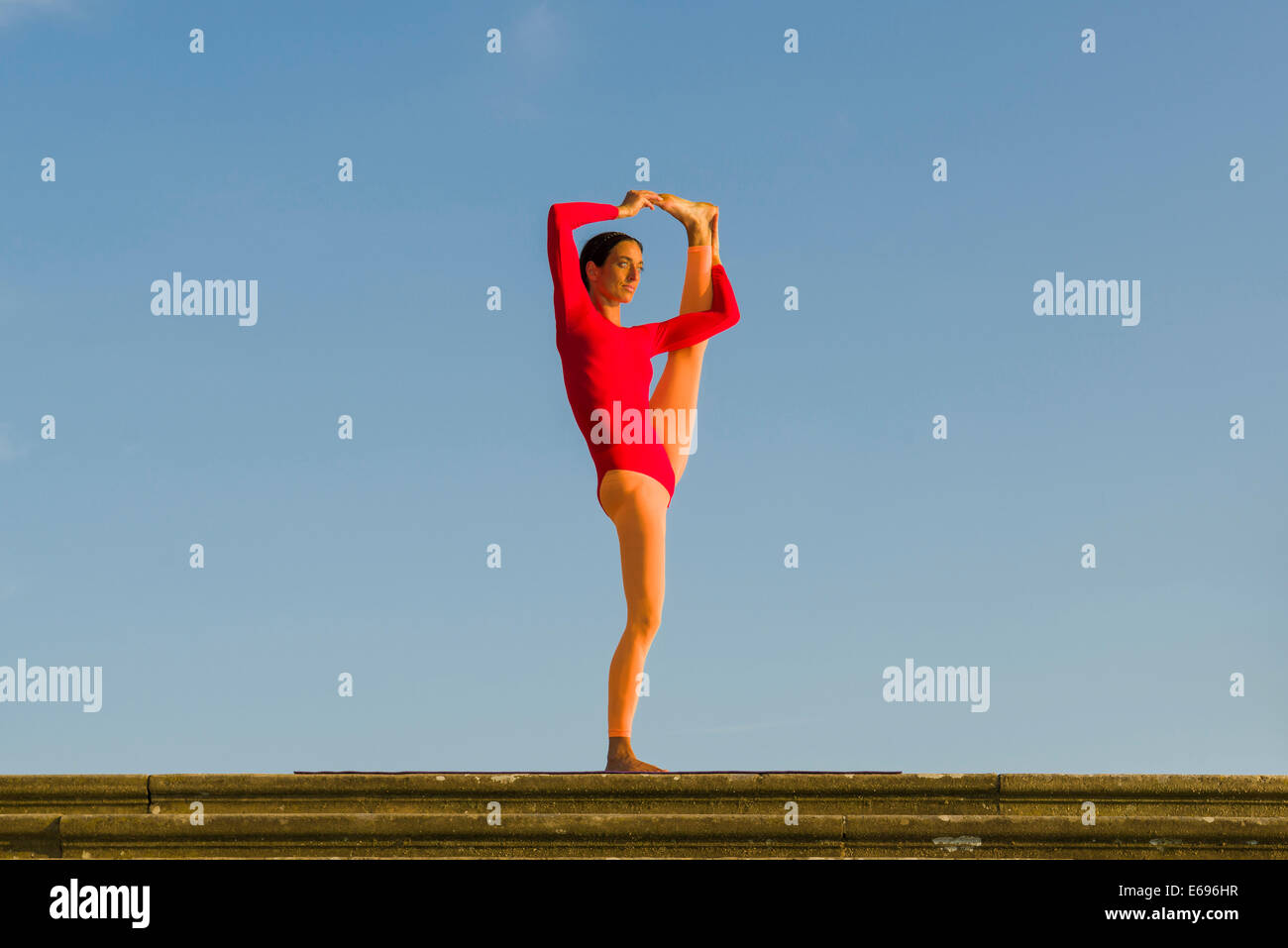 Junge Frau praktizieren Hatha Yoga im Freien, zeigen die Pose Utthita Hasta Pandangusthasana, hob die Hand zur Großzehe-pose Stockfoto