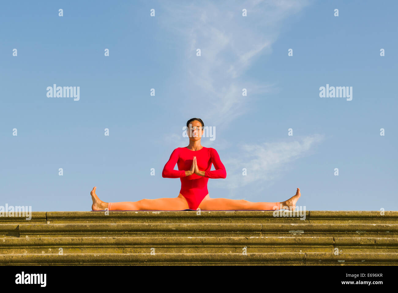 Junge Frau Hatha Yoga im Freien praktizieren, zeigt die Pose Samakonasana, rechtwinklige Pose, Seite Split Stockfoto