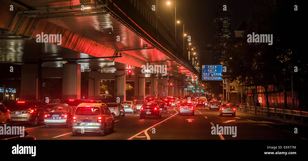 Verkehr unter einer erhöhten Straße in der Nacht, Shanghai, China Stockfoto