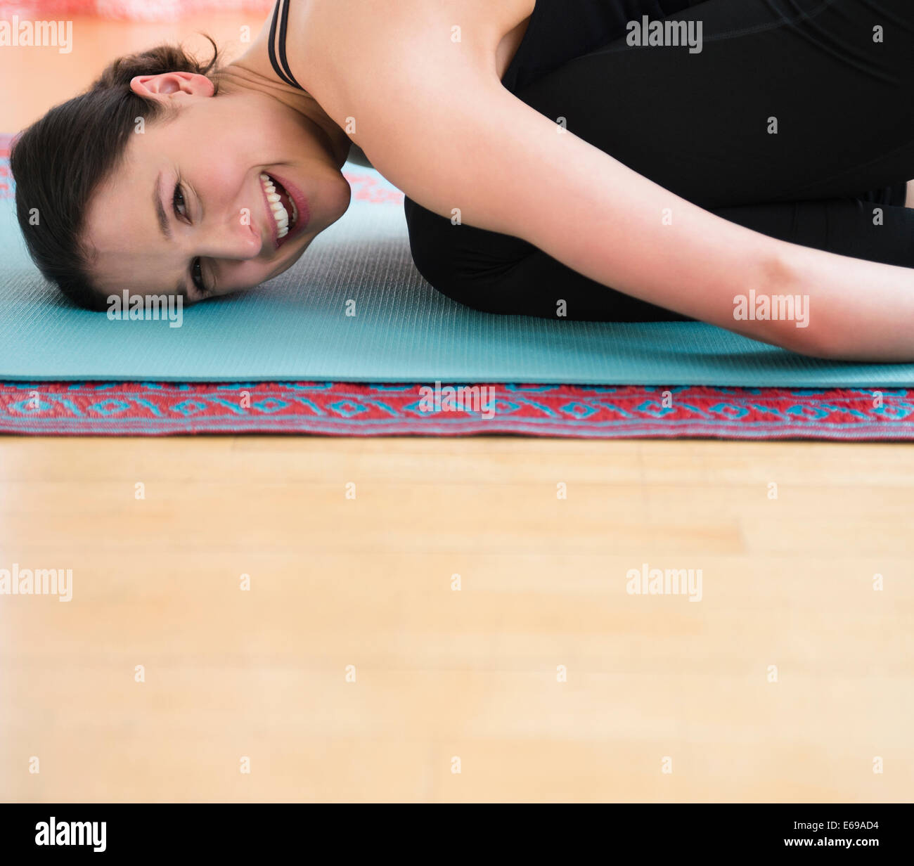 Kaukasische Frau lächelnd auf Yoga-Matte Stockfoto